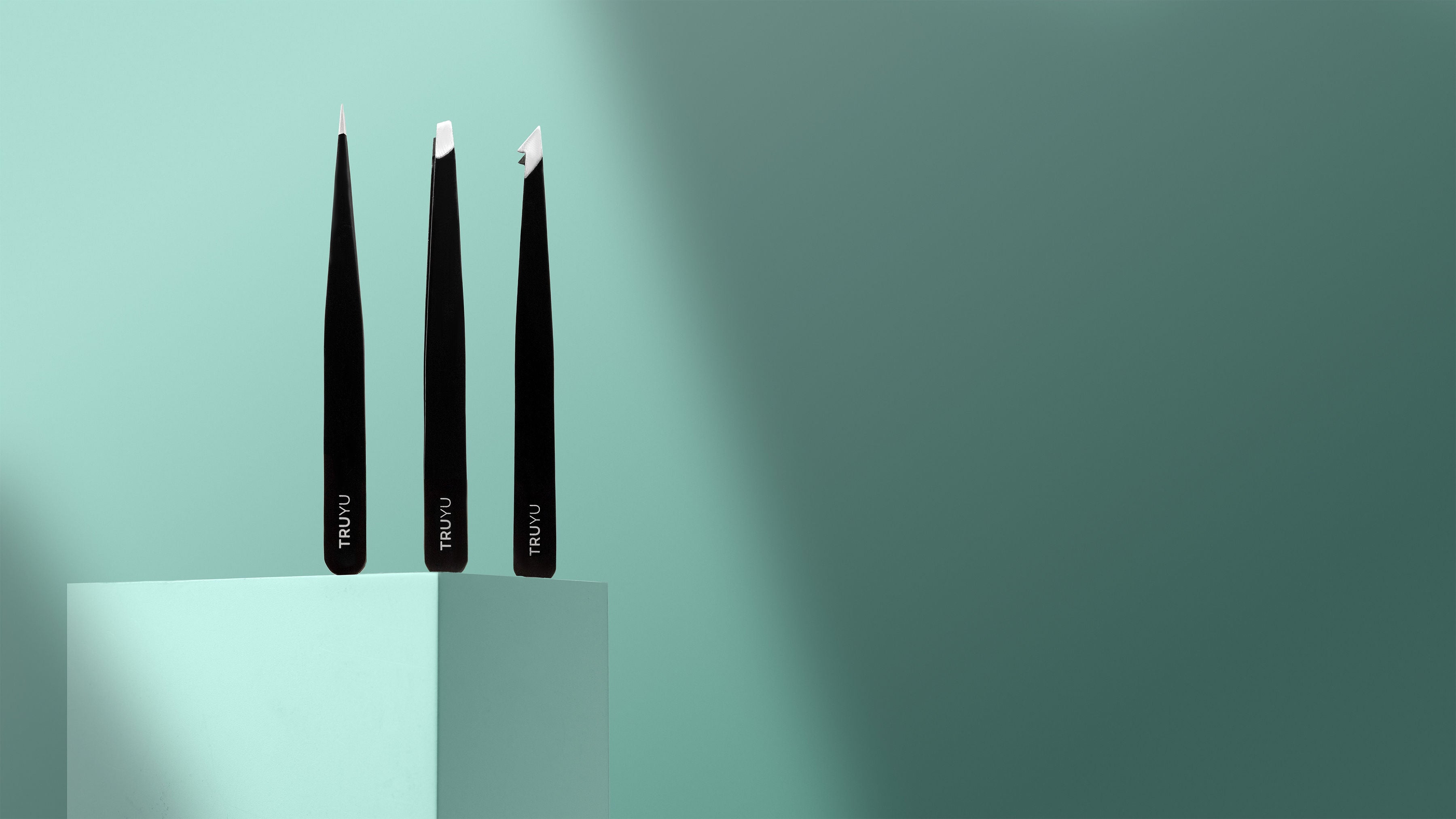 TRUYU Tweezer Trio on a mint blue background